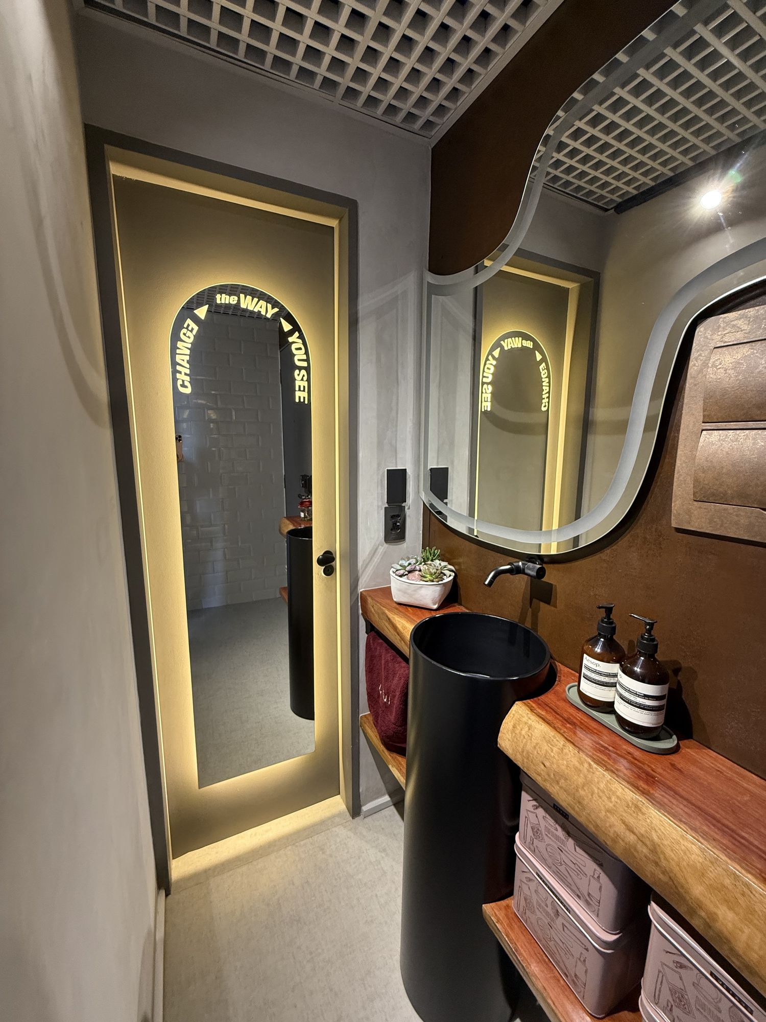 Lavabo com espelho iluminado e bancada em madeira