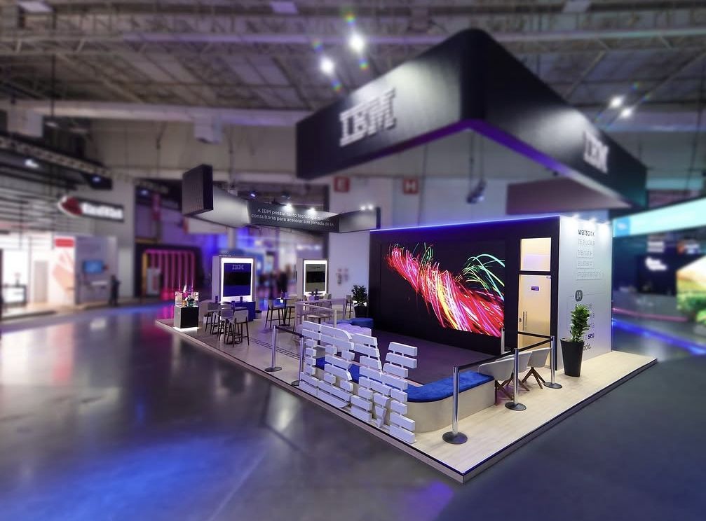 Estande preto com painel de LED e letreiro no piso