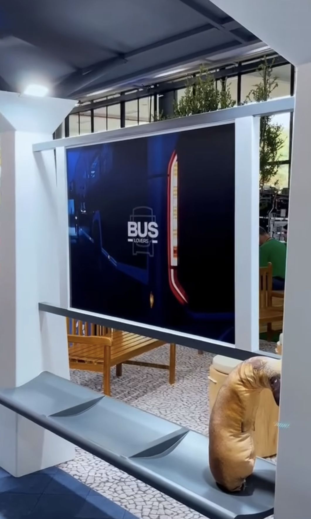 Abrigo cenográfico com painel de vídeo e banco