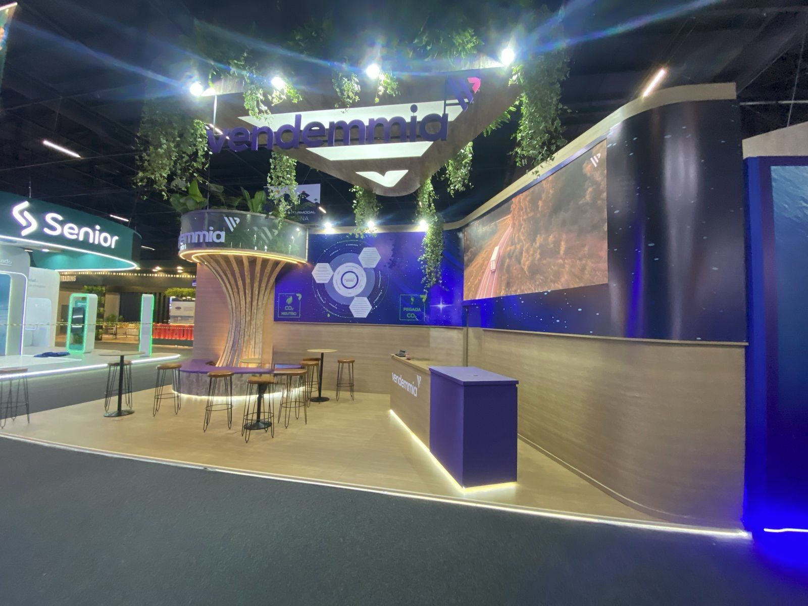 Estande com vegetação suspensa e painel de LED